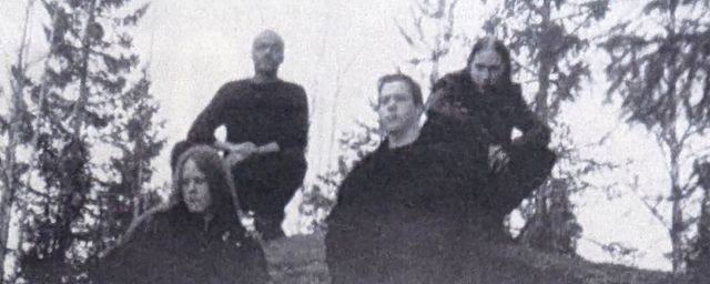 The band standing on top of a large boulder.